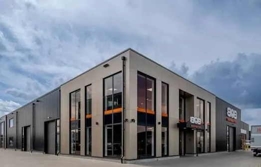 BOB Distribution's building from the side: a dark grey facade with large windows, orange accents and the BOB logo.