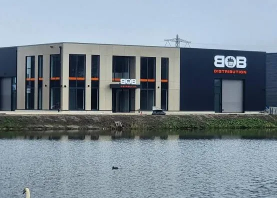 BOB Distribution's building seen across the water, with a swan in the foreground.