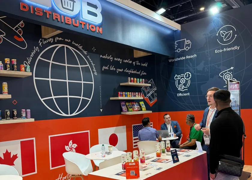 The BOB stand from the side: a globe on the wall, shelves with products and visitors talking at a table.
